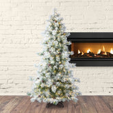 Decorated Christmas tree with lights in front of a fireplace against a white brick wall.