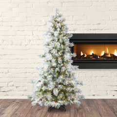 Decorated Christmas tree with lights in front of a fireplace against a white brick wall.